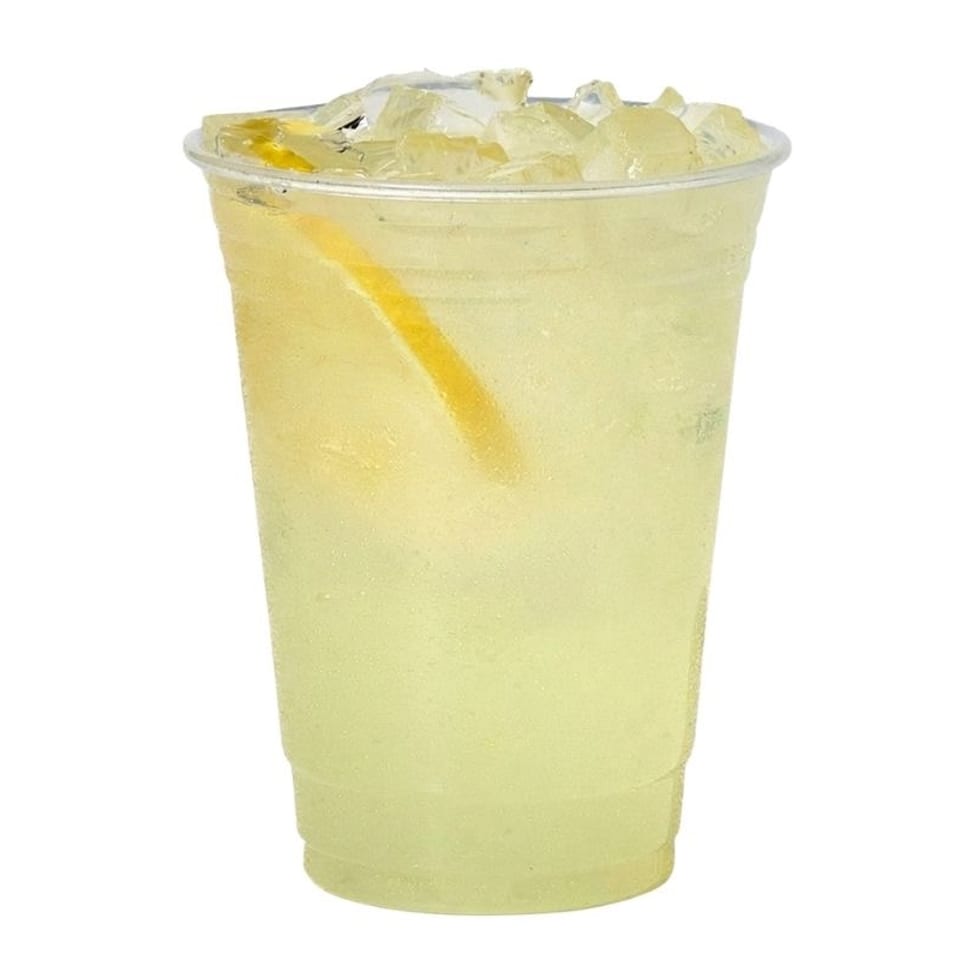 Pale yellow iced lemonade in a clear plastic cup with a lemon wedge, against a white background.