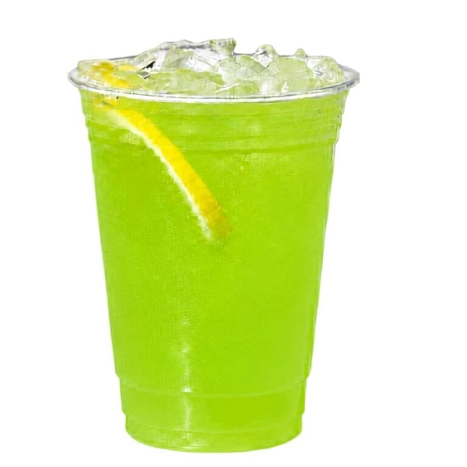 Bright green iced drink in a clear plastic cup with a lemon slice, photographed against a white background.