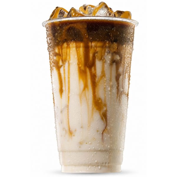 Iced coffee with caramel drizzle and ice in a clear plastic cup, condensation on the outside.